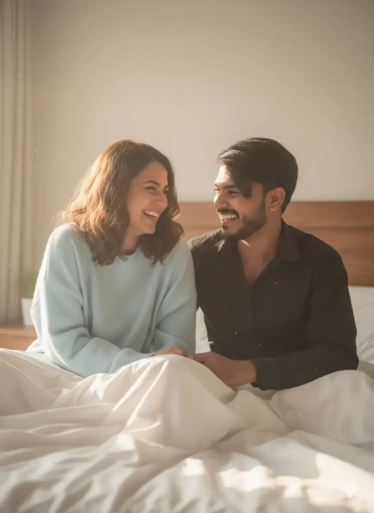 Couple laughing on bed in cozy morning light